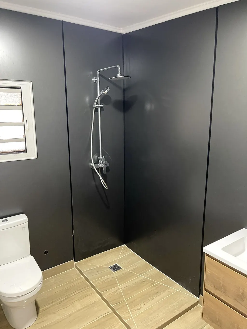 Douche avec habillage Alucobond noir et sol bois